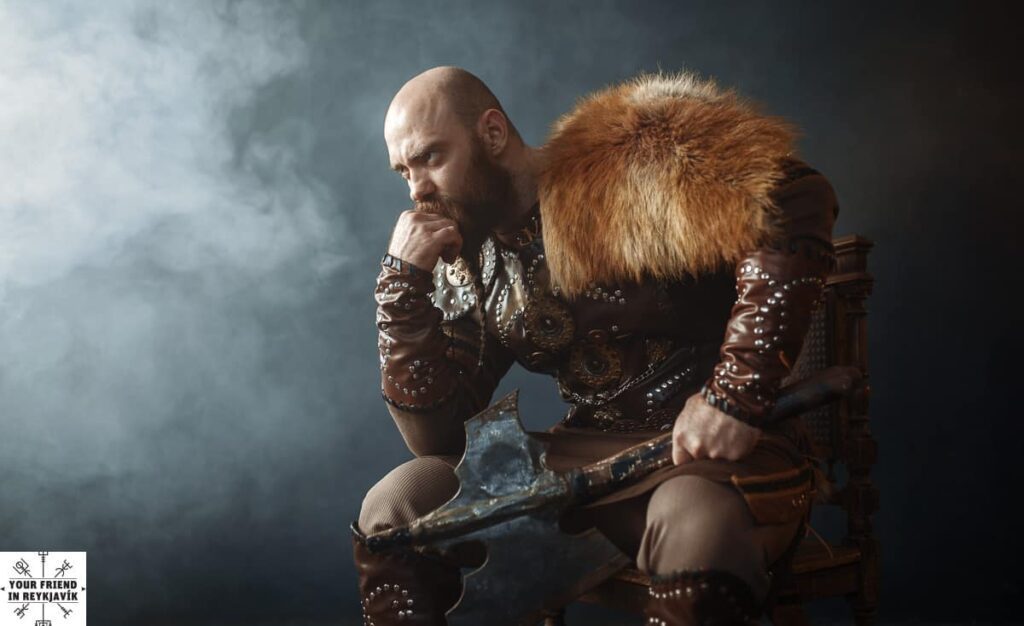 Thoughtful viking with axe sitting on chair